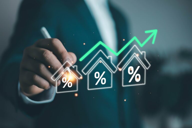 Dirigeant pointant trois icônes de maisons avec symboles pourcentage et flèche verte ascendante — concept de hausse des taux et cotisations